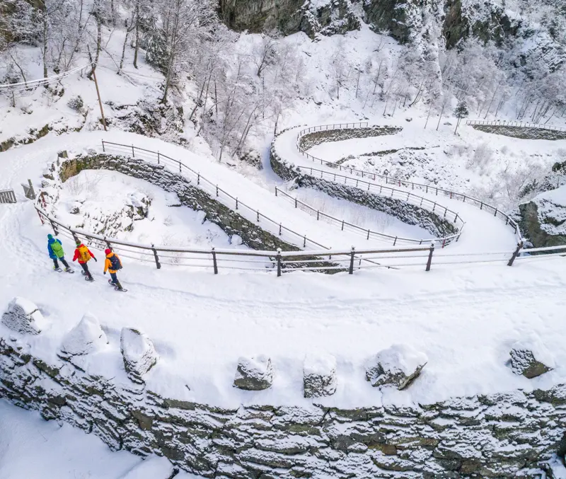 Three people on a snowshoe hike on Kongevegen, Vindhellavegen