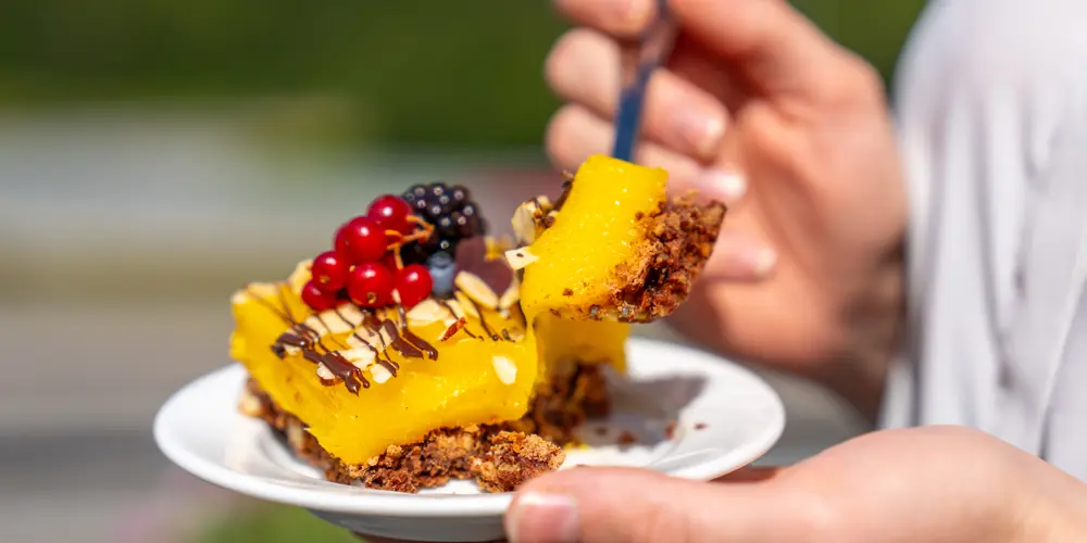 Someone takes a bite of a success cake on an outdoor patio