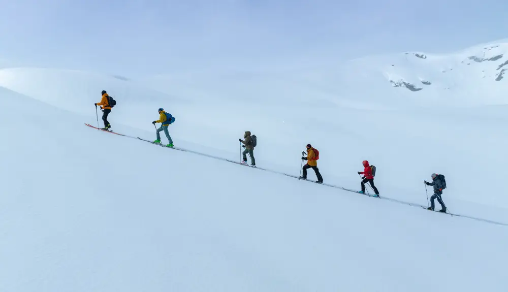 Participants on randonnée and summit hike courses going uphill in beautiful winter scenery
