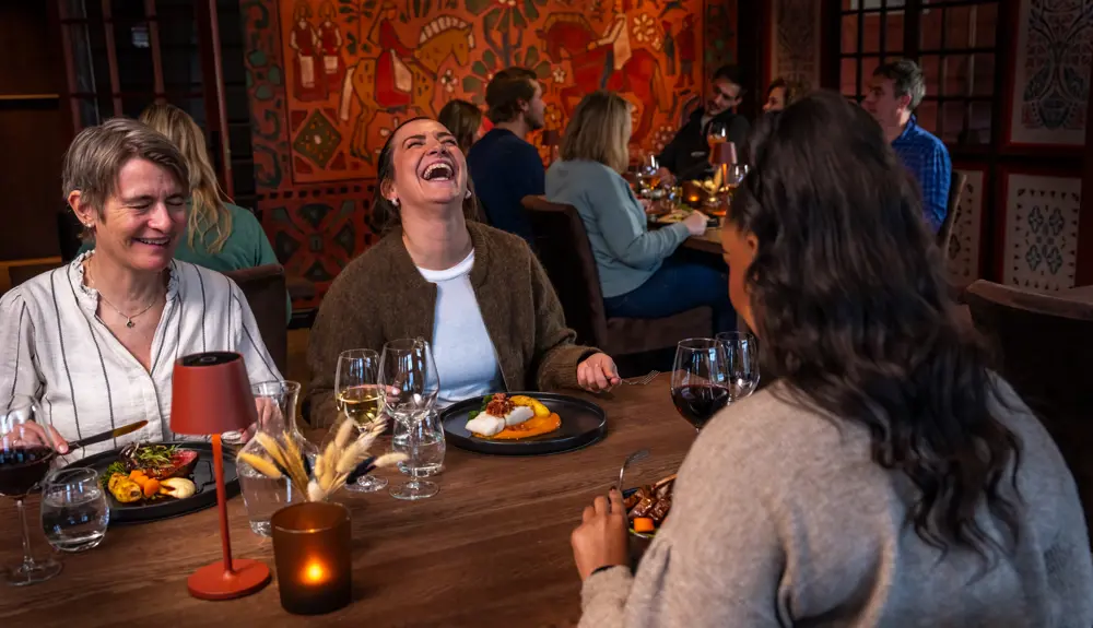 Venner og familier nyter et måltid sammen på Filefjellstuene