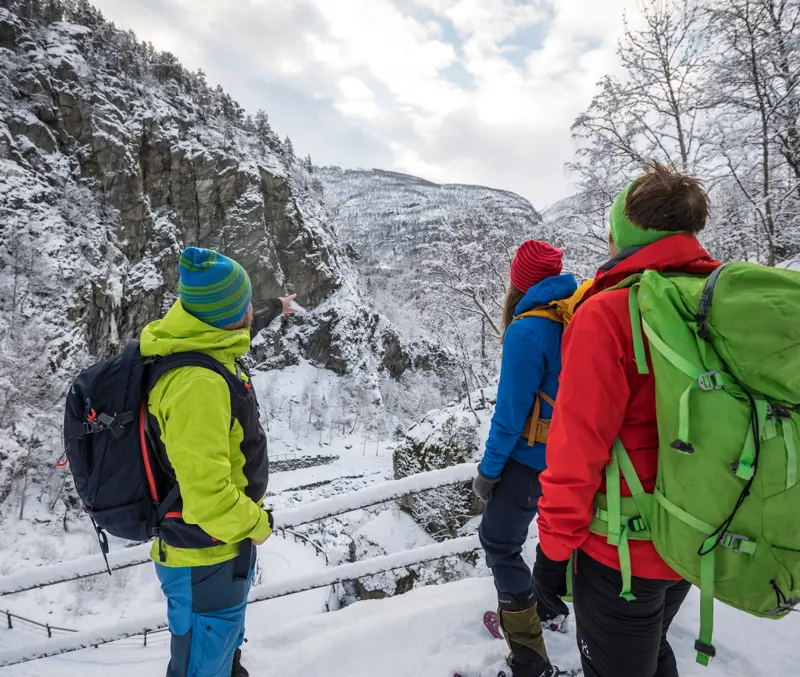 Three people on a snowshoe hike on Kongevegen, Vindhellavegen