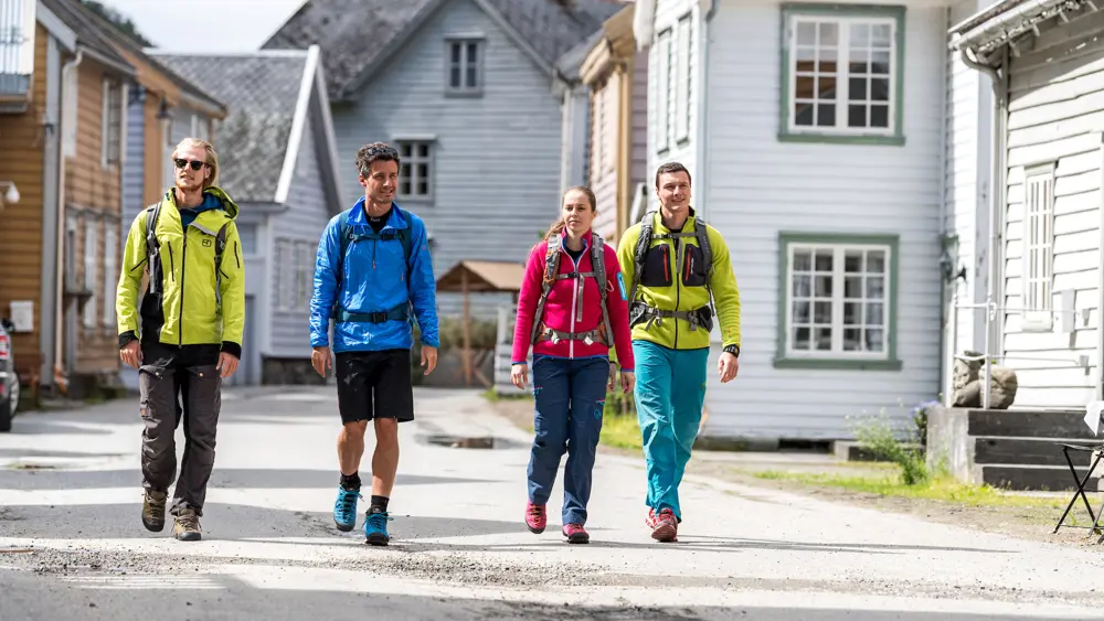 Hikers on Kongevegen walk between the traditional wooden houses at Lærdalsøyri