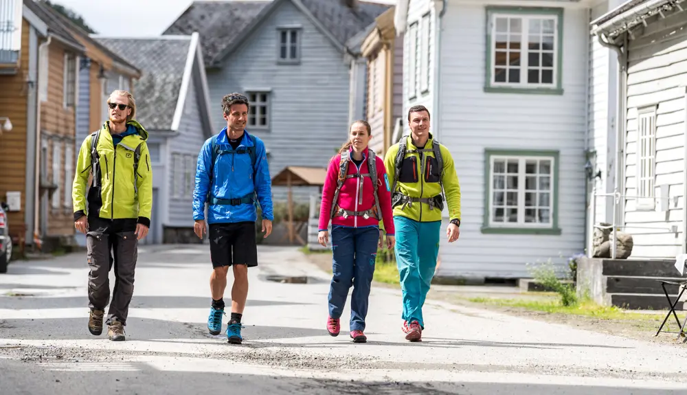 Hikers on Kongevegen walk between the traditional wooden houses at Lærdalsøyri